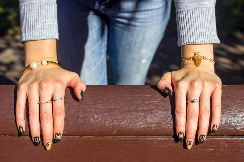 Close up of my hands on a bench, showing my nail art and rings