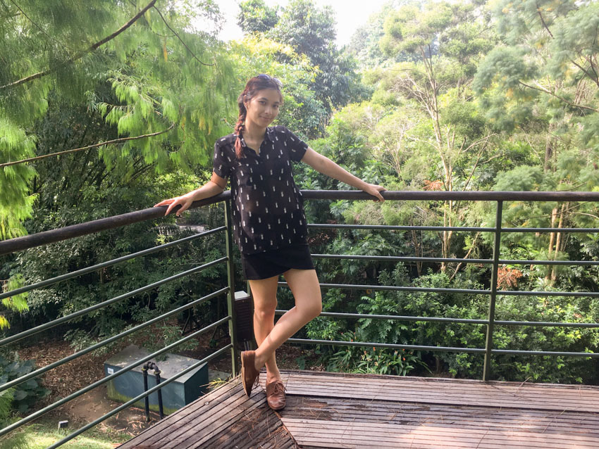 Me leaning in the corner of a wooden walkway above ground