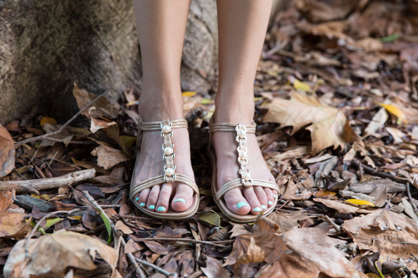 Close-up of my feet in sandals, amongst fallen leaves