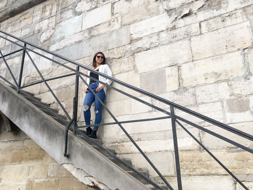 Me leaning on a wall with a set of stairs, by the Seine River