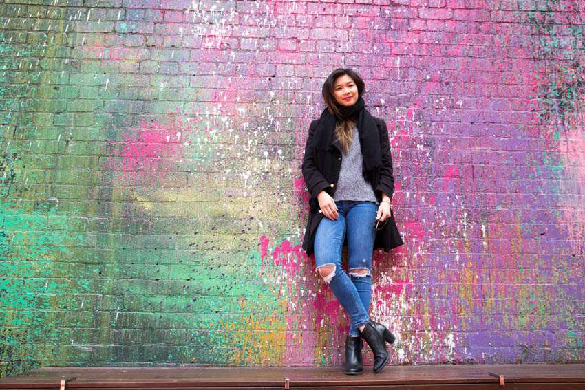 Me standing in front of a bright colourfully painted wall