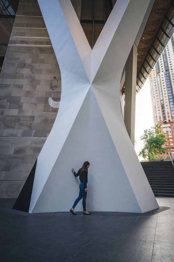 Walking in front of an interesting X-shaped white pillar