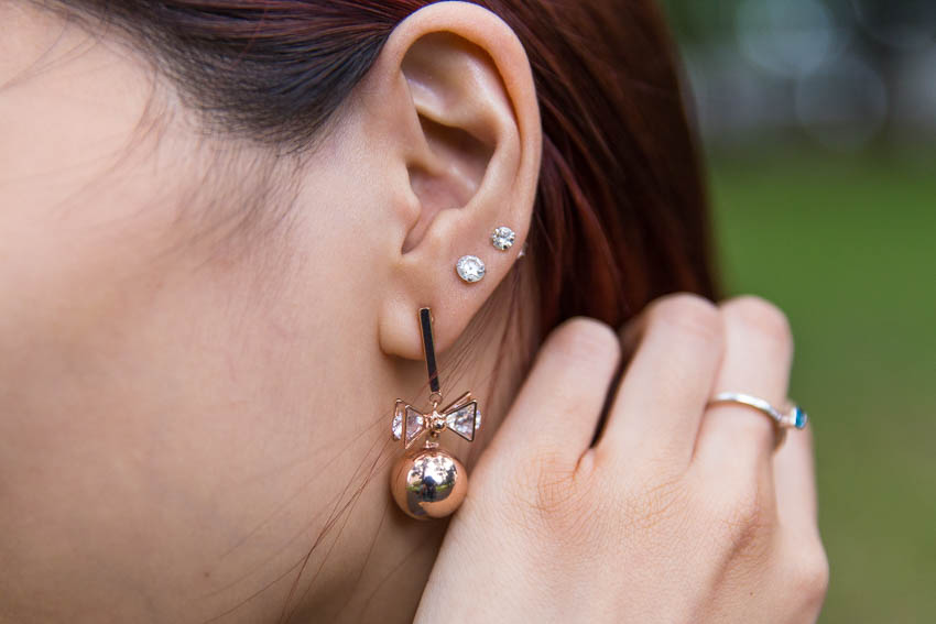 Close up of rose gold ball and bow earrings