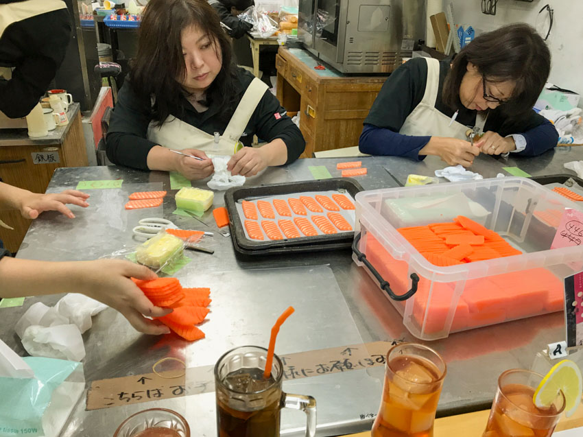 Some workers at Sample Kobo creating some raw salmon replicas by hand