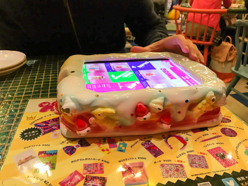A large plastic rectangular cake with a digital screen on top, resembling an iPad