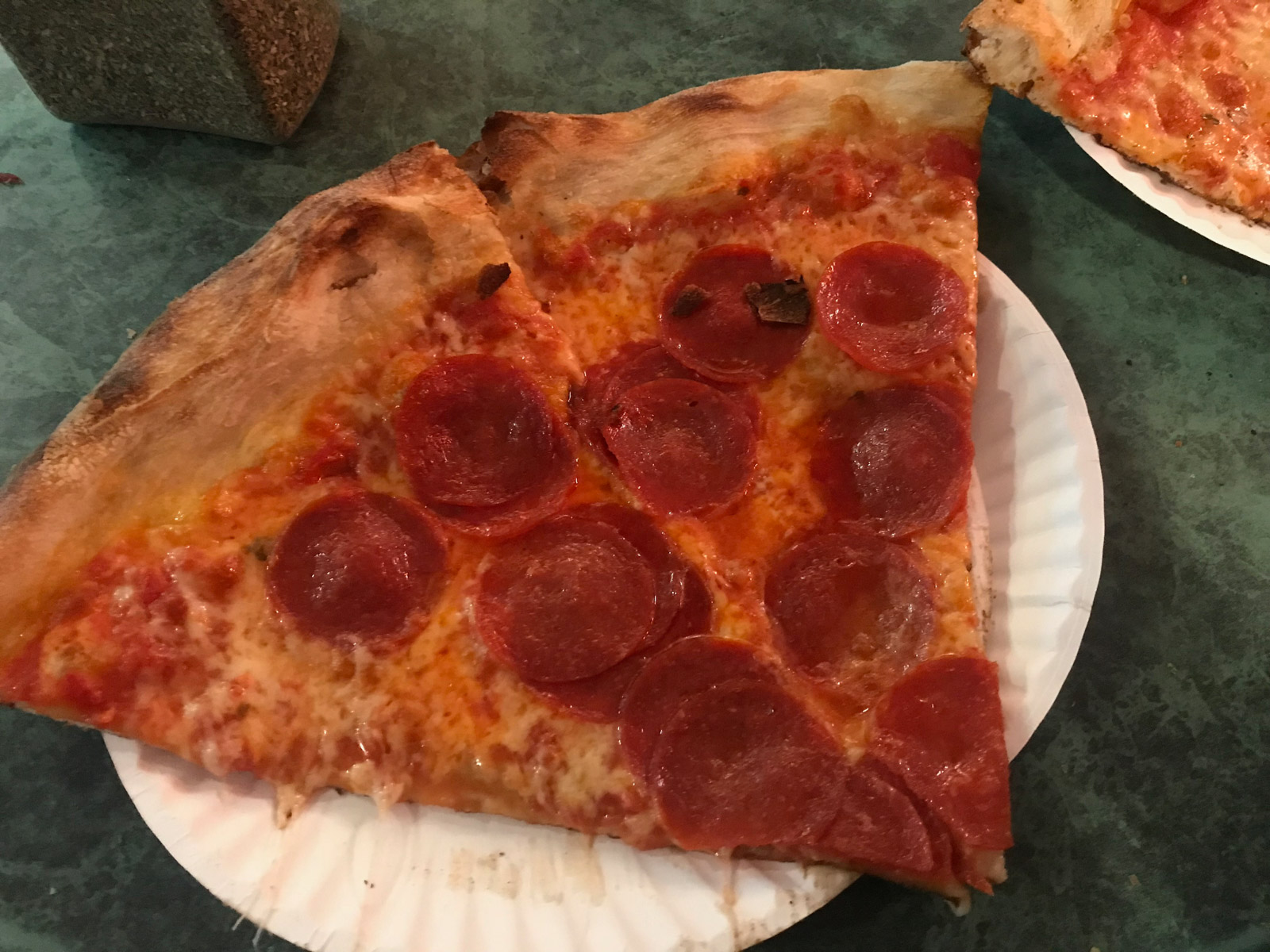 A few slices of pepperoni pizza on a white paper plate