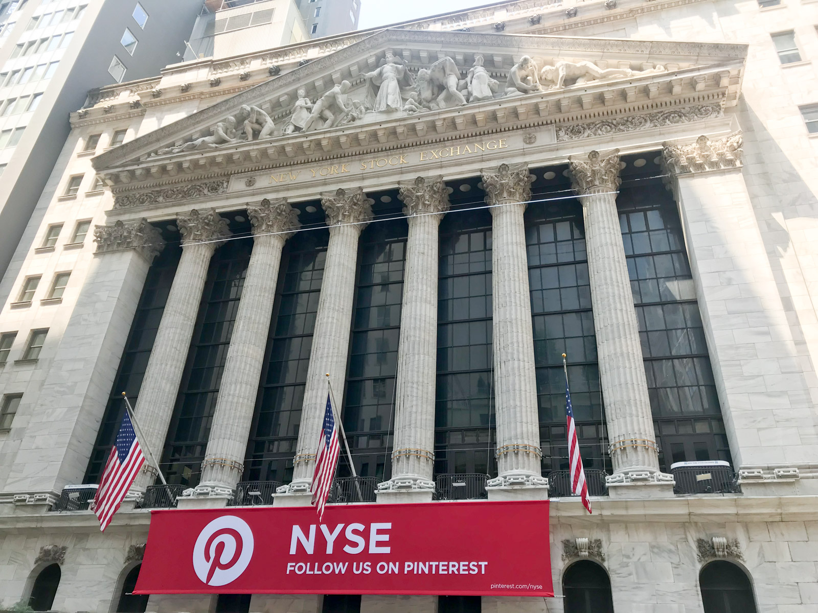 A traditional stone building with lettering “New York Stock Exchange”. Its front resembles pillars and tall windows