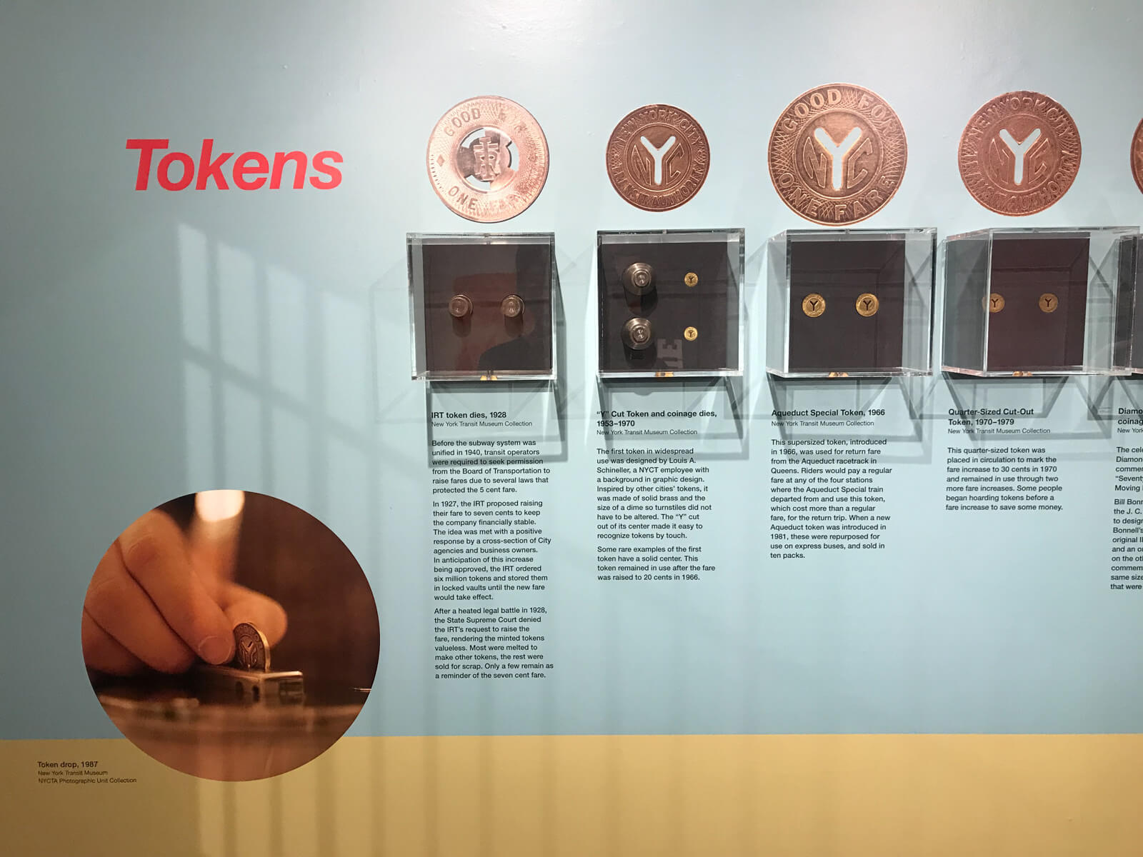 A display of several small glass cabinets showcasing different types of tokens used to pay for train fares
