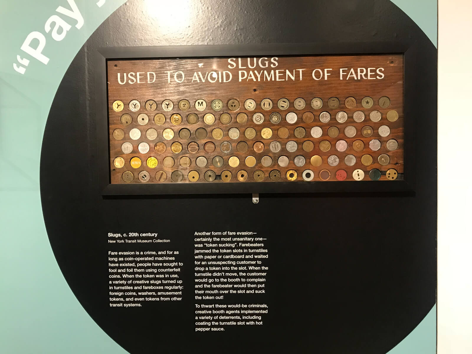 A display on a wall of many different fake tokens, resembling metal coins, used to avoid paying fares to ride the train