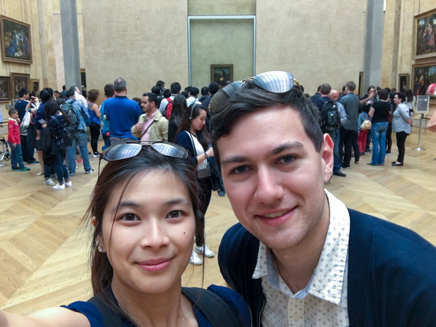 Myself and Nick distanced from a crowd looking at the famous Mona Lisa painting in the background