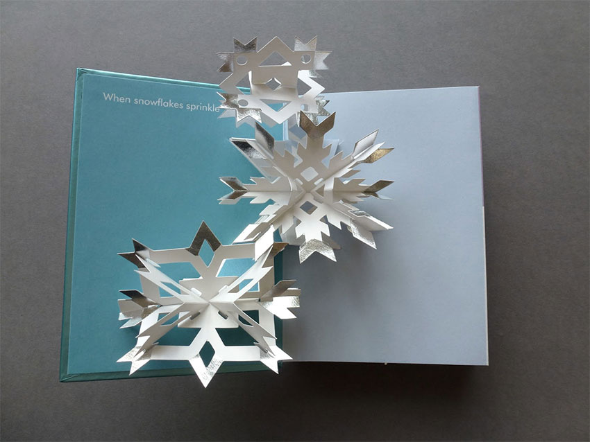 A pop-up book open to a page with a snowflake