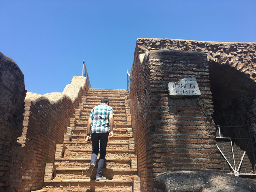 Nick walking up some stairs in a ruin in Ostia Antica