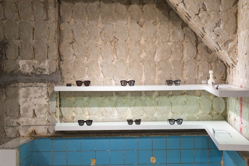 Front-on view of sunglasses with some old bath tiles visible