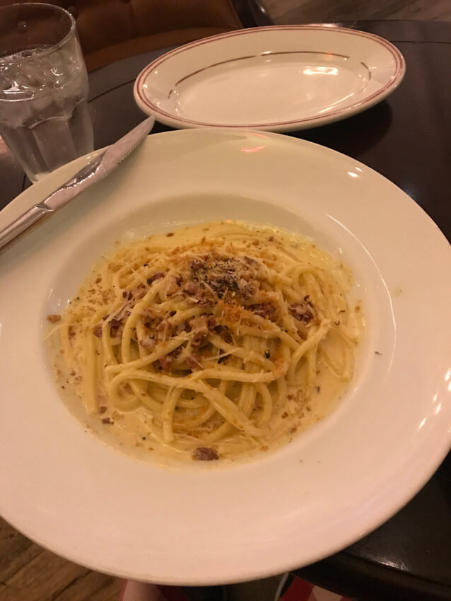 A white plate of spaghetti carbonara