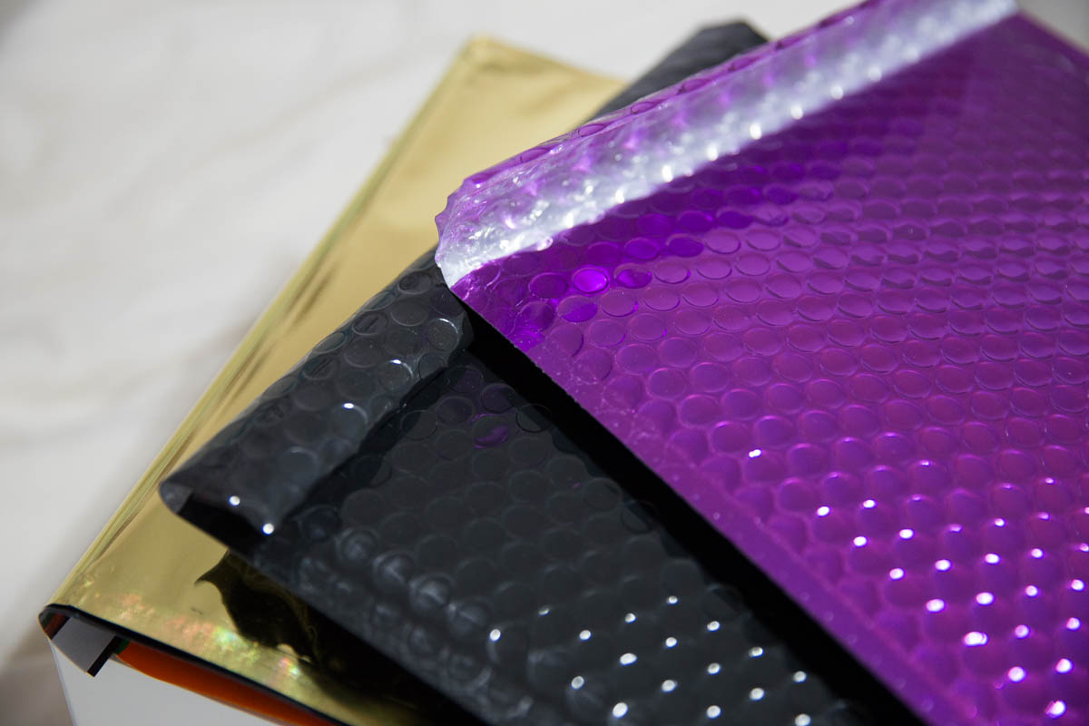 Large bubble bags in metallic purple and black. Some foil envelopes underneath