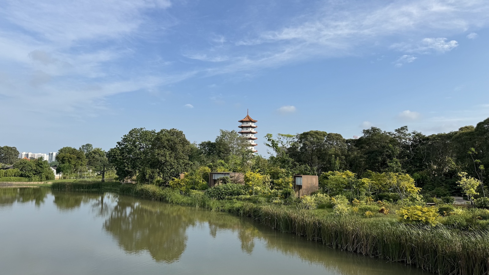 Pond with trees and a multi-tiered pagoda reflected in the water.