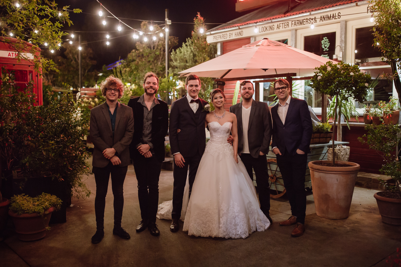 A bride and groom with four other men dressed in suits