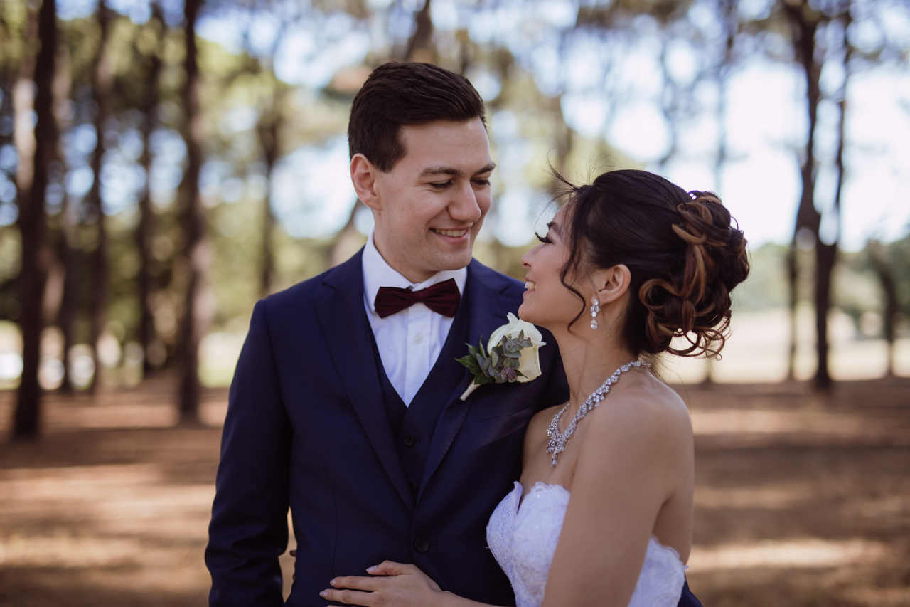 A bride and groom smiling and looking into each other’s eyes