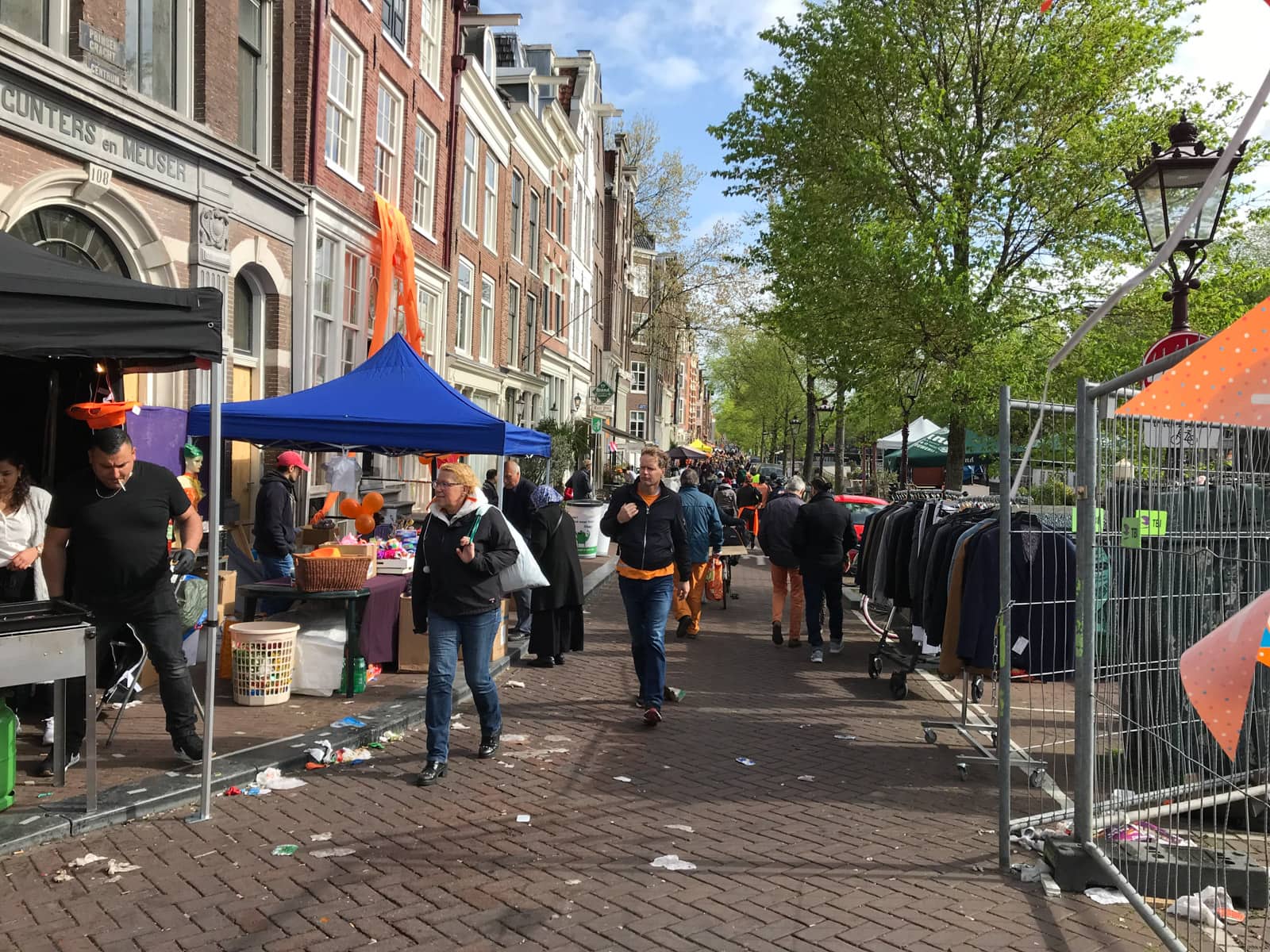 A street market on the side of a canal. It’s relatively busy with people setting up