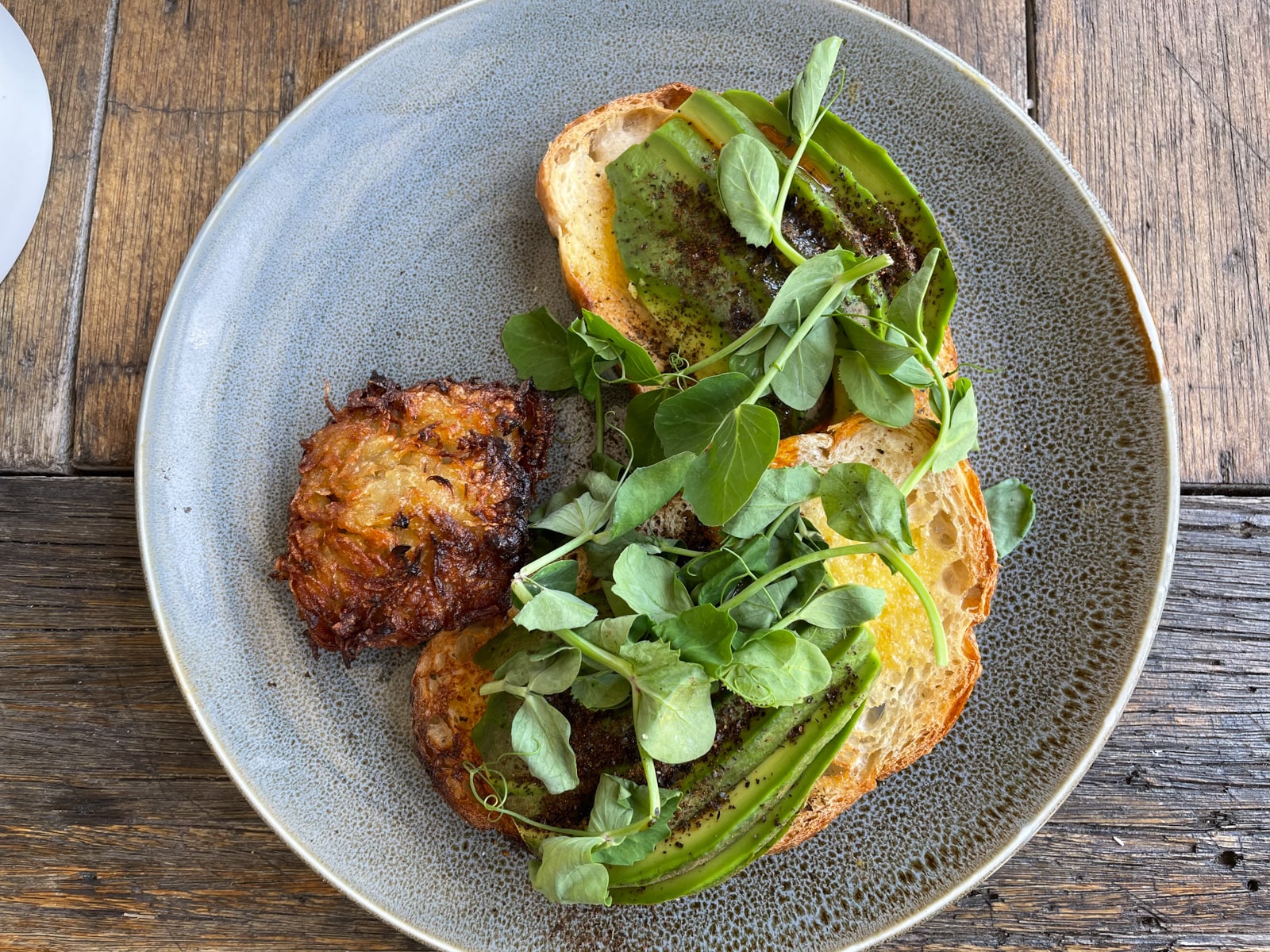 A plate with toast served with avocado, nori seaweed and chilli oil