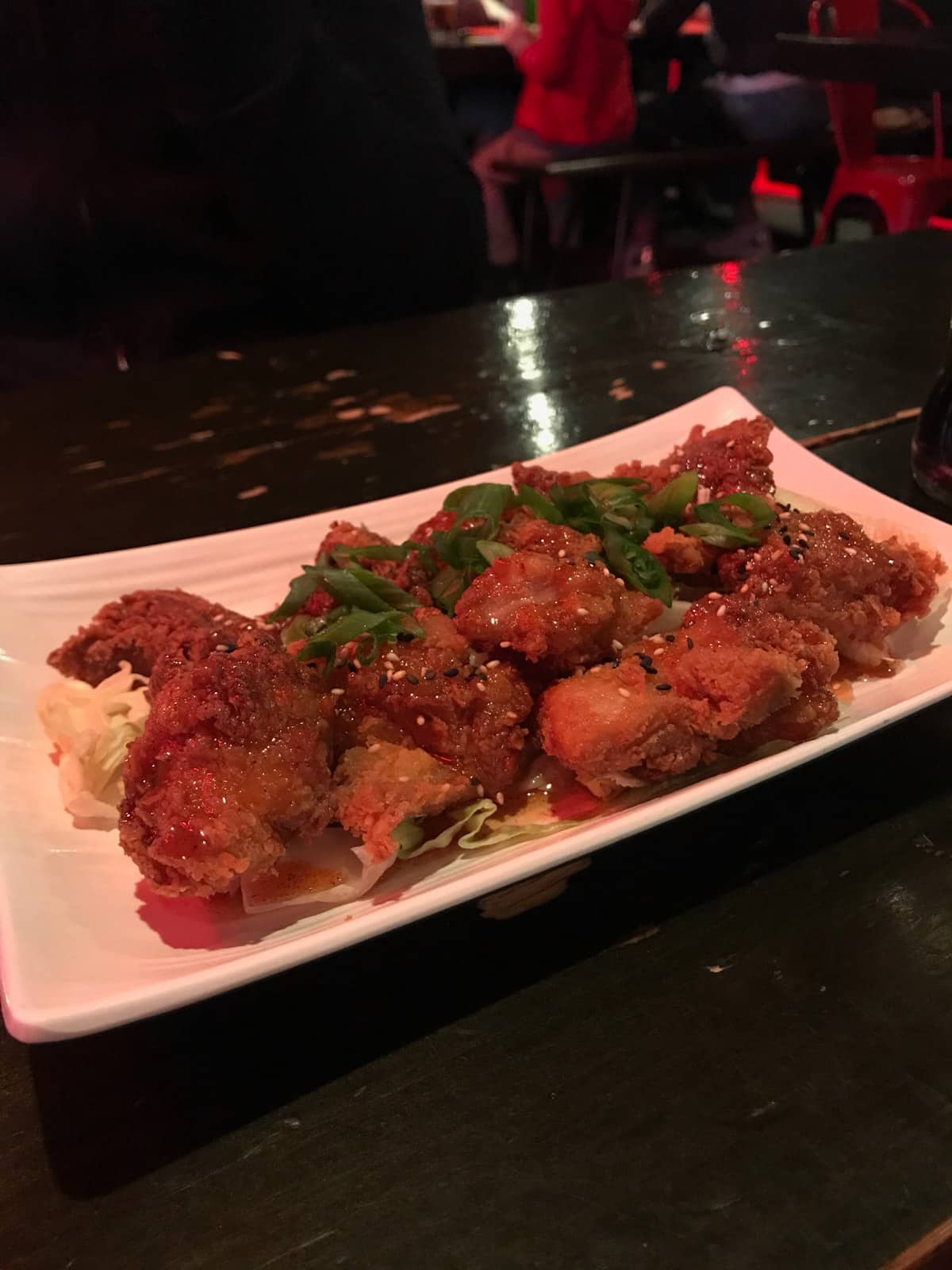 Fried chicken on a rectangular white plate, on a table in a restaurant