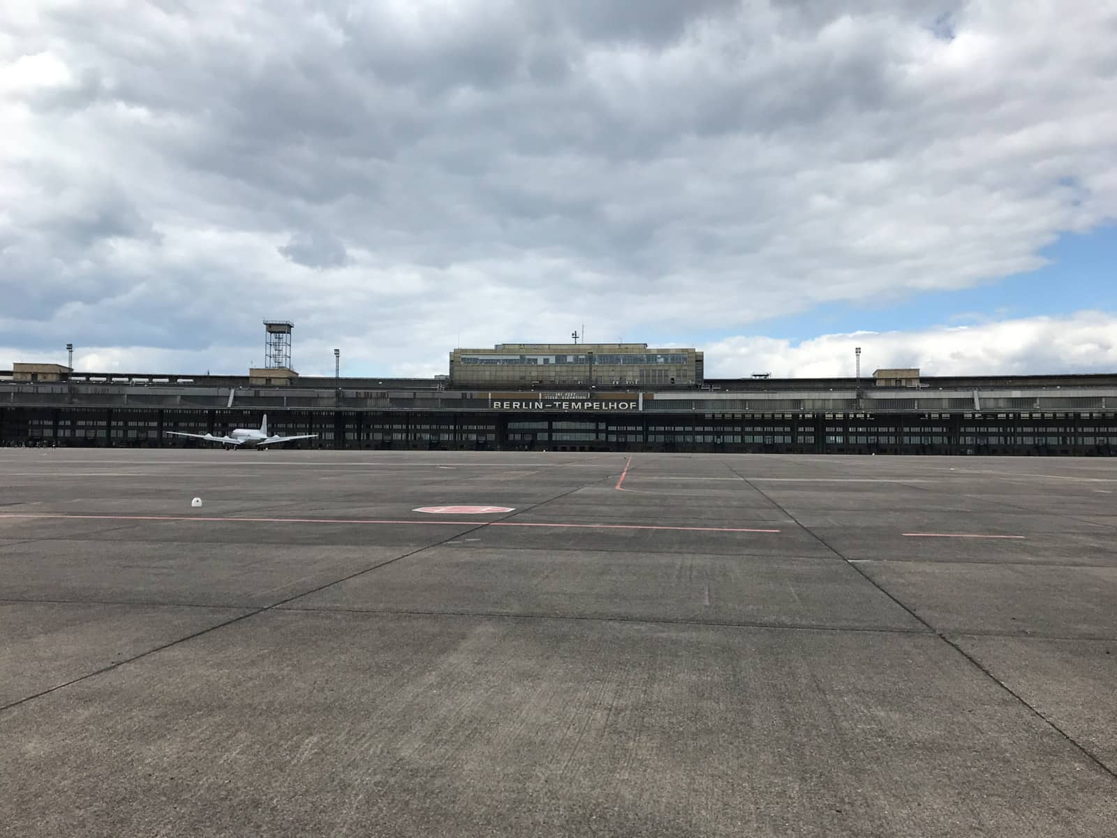 A building with the sign “Berlin – Tempelhof” with a plane towards the left. Much of the foreground is open space