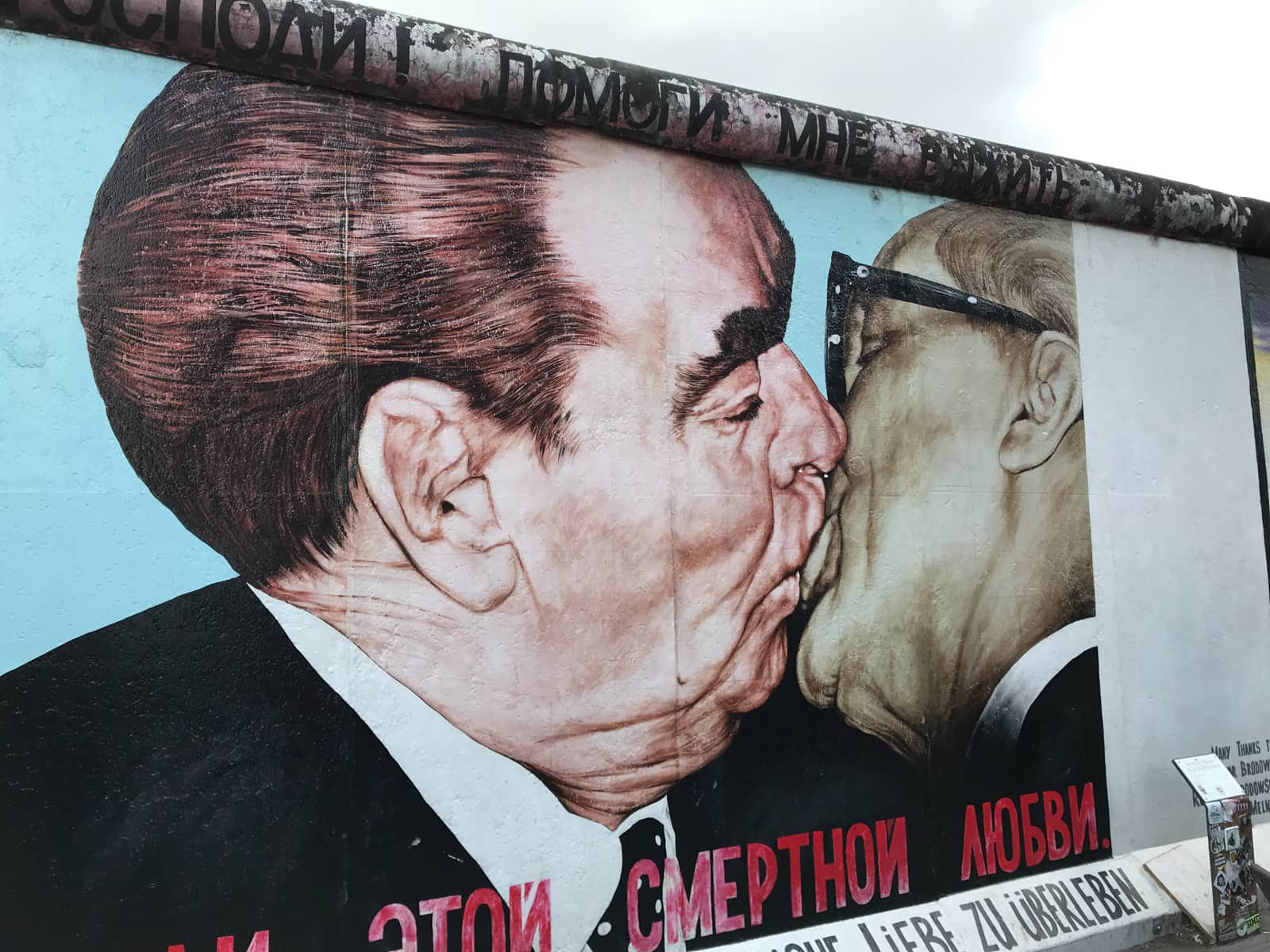 An artwork on the Berlin Wall of two men kissing.