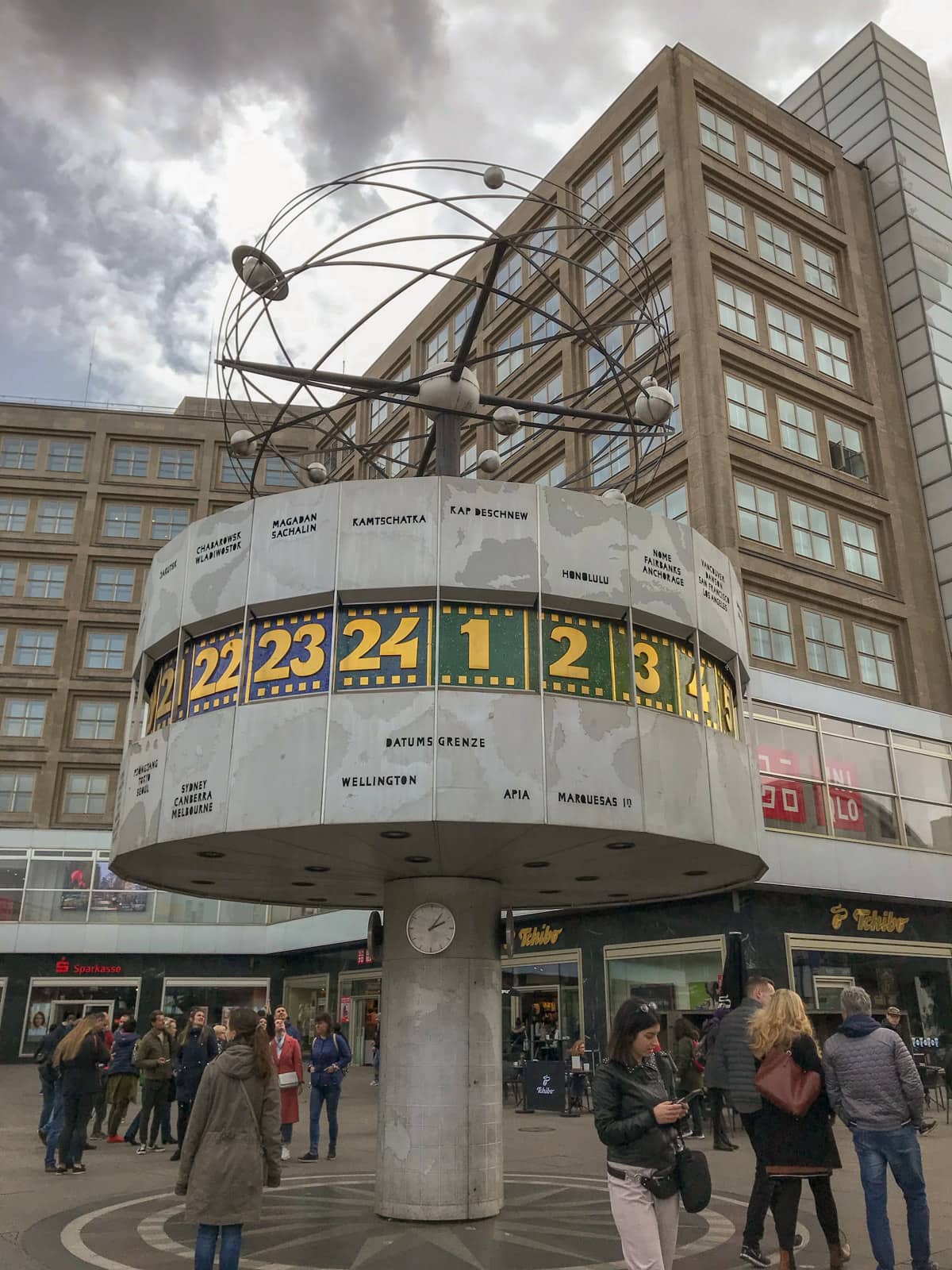 A monument in a turret shape, displaying various countries and numbers on a strip in the middle of the turret representing what hour of the day is being observed in each city.