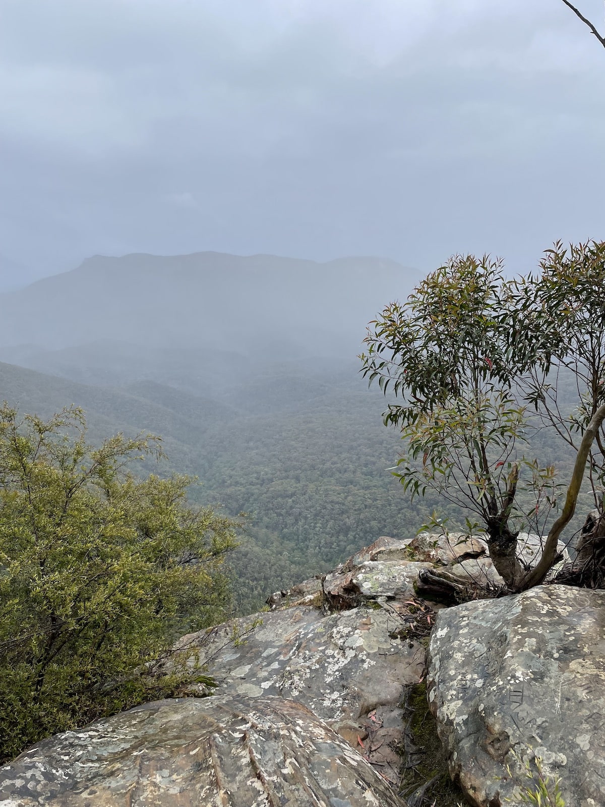A foggy mountain valley as seen from a rocky cliff edge
