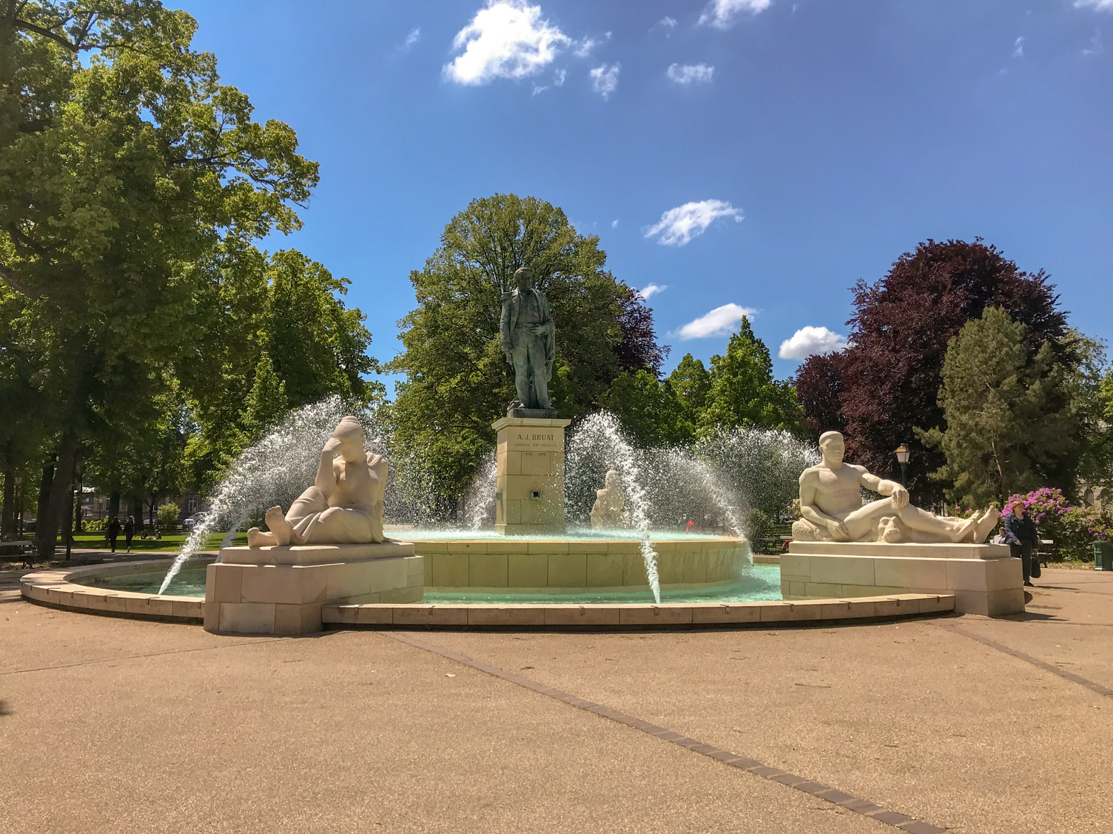 A water fountain with some statue figures