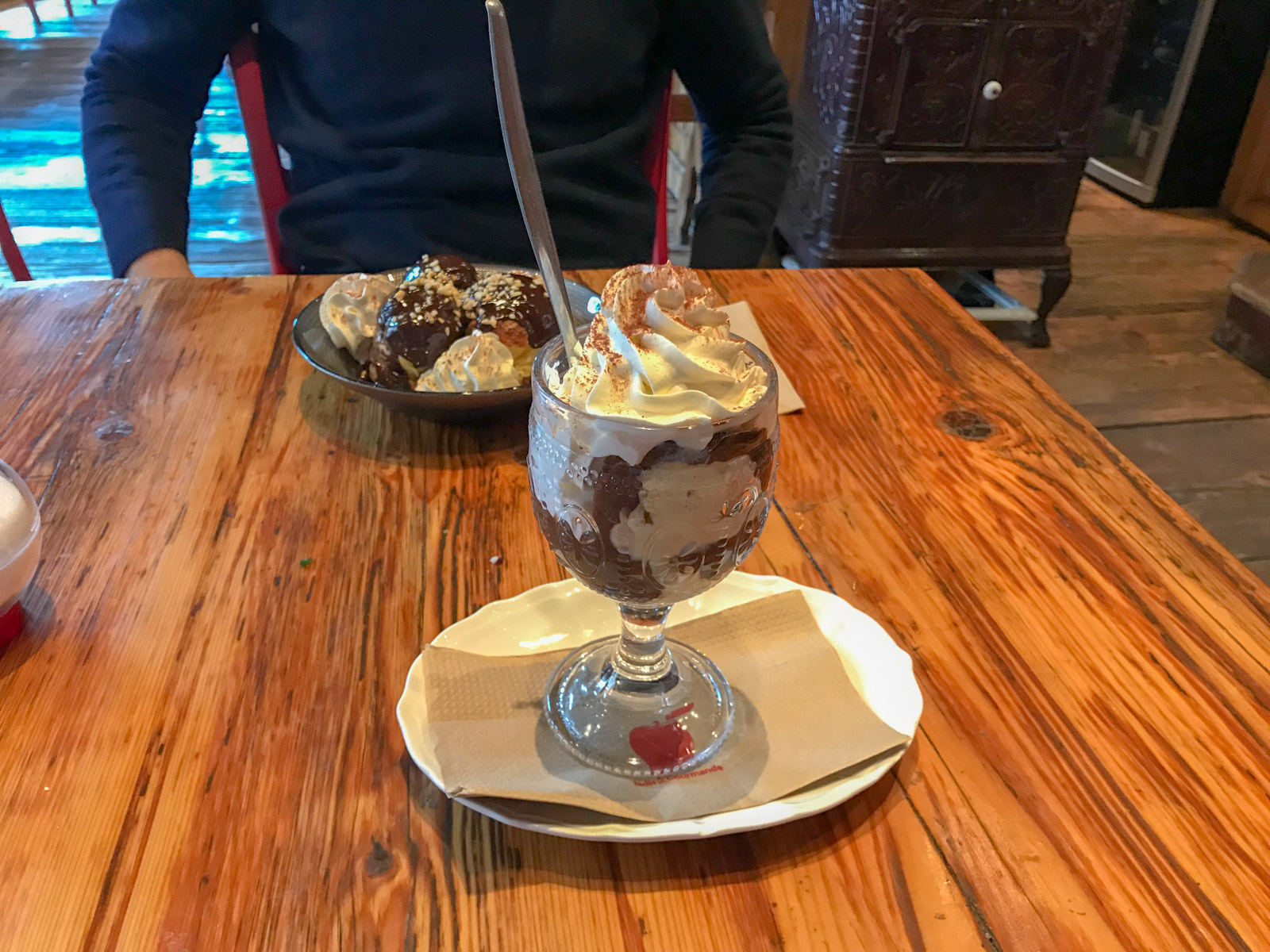 A small glass of chocolate dessert topped with whipped cream