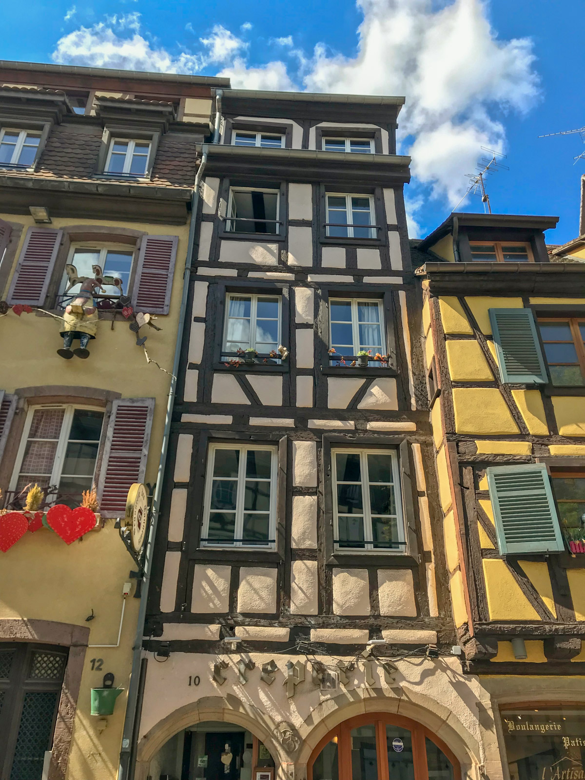 A low-angle view of an old building with tall glass windows.