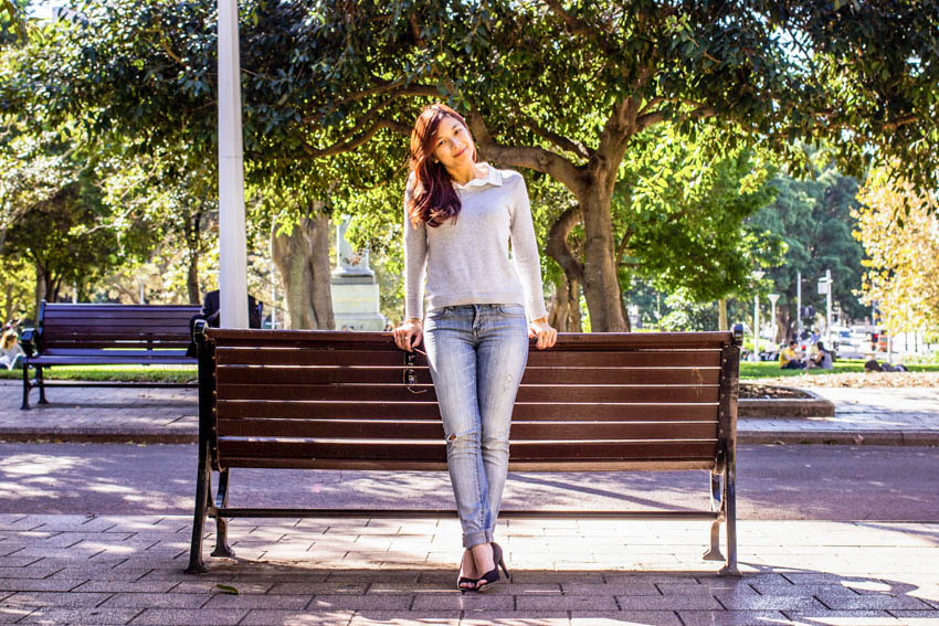 Full body shot of me standing and leaning on the back of a bench.