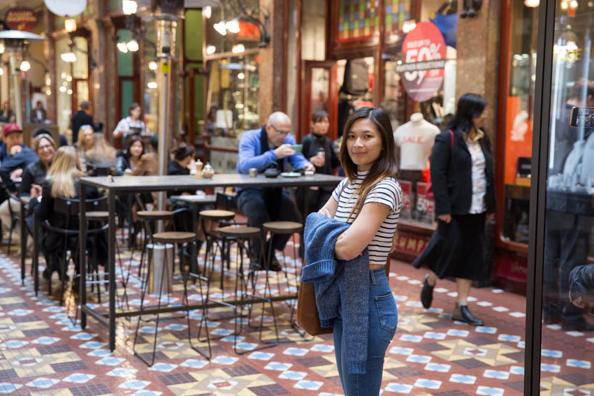 Me standing near the open dining area in the mall, with my sweater in my arms