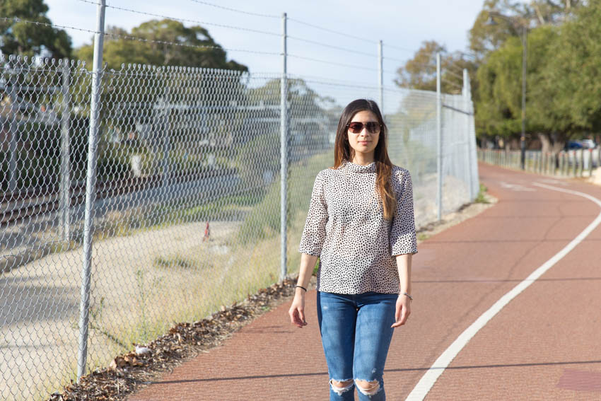 Me walking down a bike track next to a barbed wire fence by the train tracks