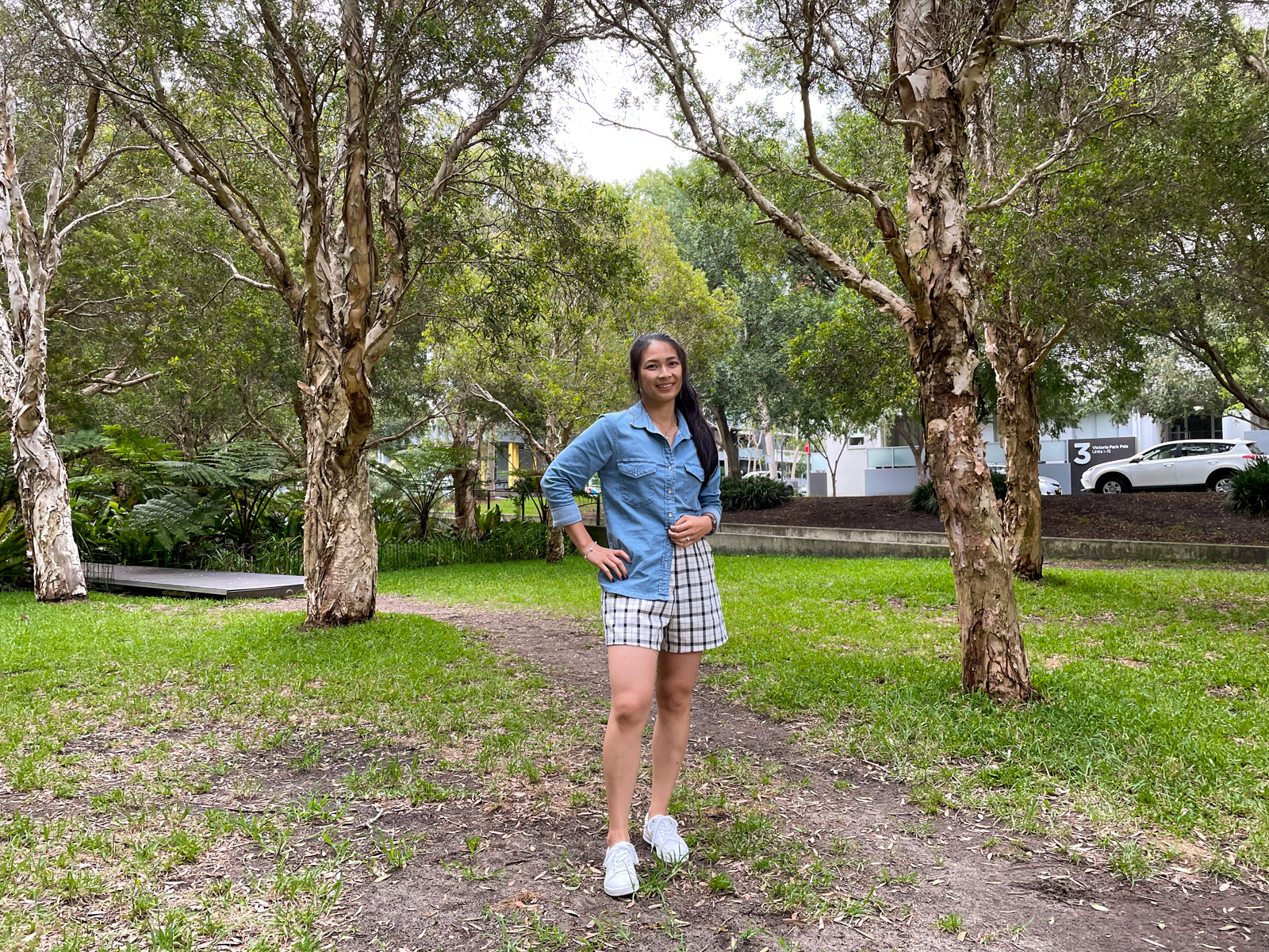 A full body photo of the same woman in previous photos in this post, wearing the same outfit. She is wearing white sneakers and has a hand on her hip.