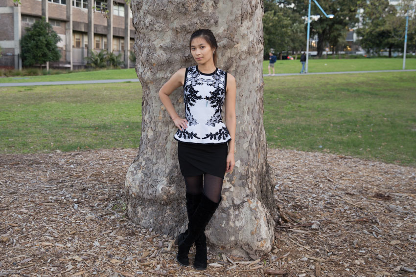 Full body shot in front of a tree trunk with one hand on my hip, one foot crossed in front of the other