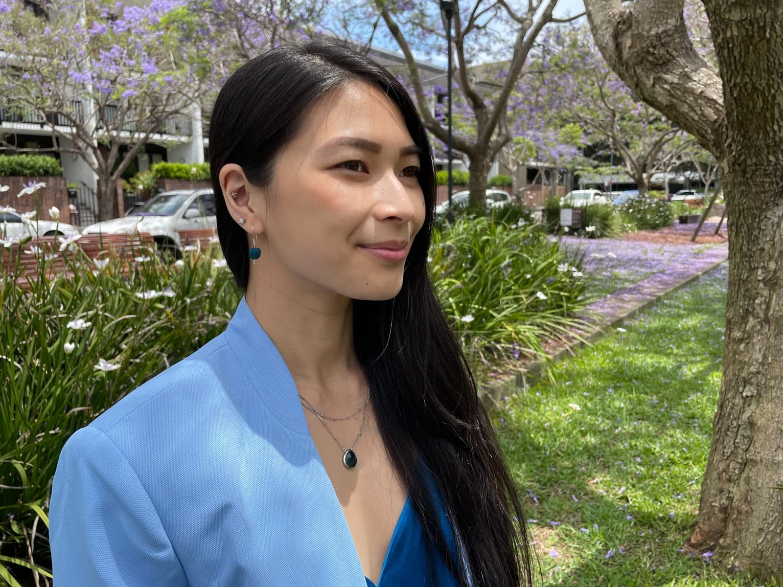 A close-up of the woman in earlier photos in this post, showing her side profile. She has a silver necklace with a dark blue gem, and silver earrings, one of which has a dark blue gem