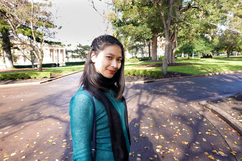 The same woman from the previous photo, wearing the same clothes. She is angled slightly towards the camera and smiling.