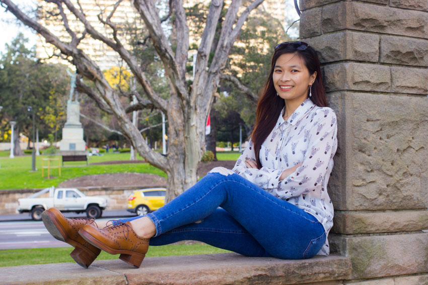 Me sitting and leaning against a stone pillar with my arms folded