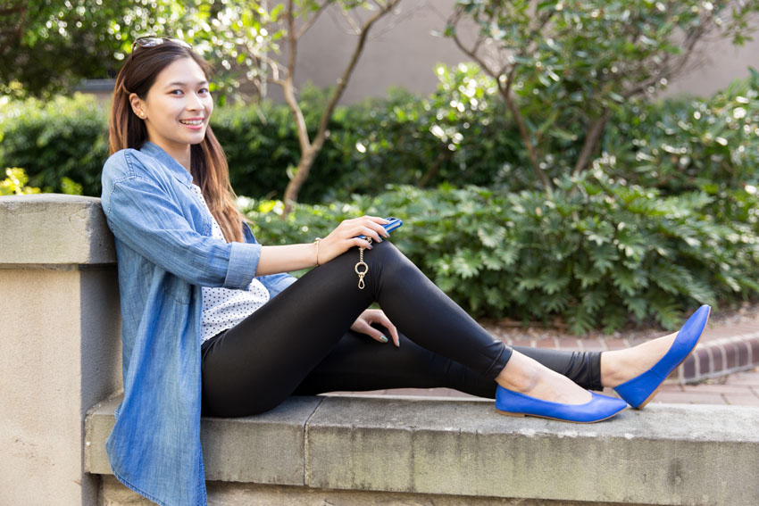 Me sitting on a short brick wall, leaning on a short pillar with one knee bent