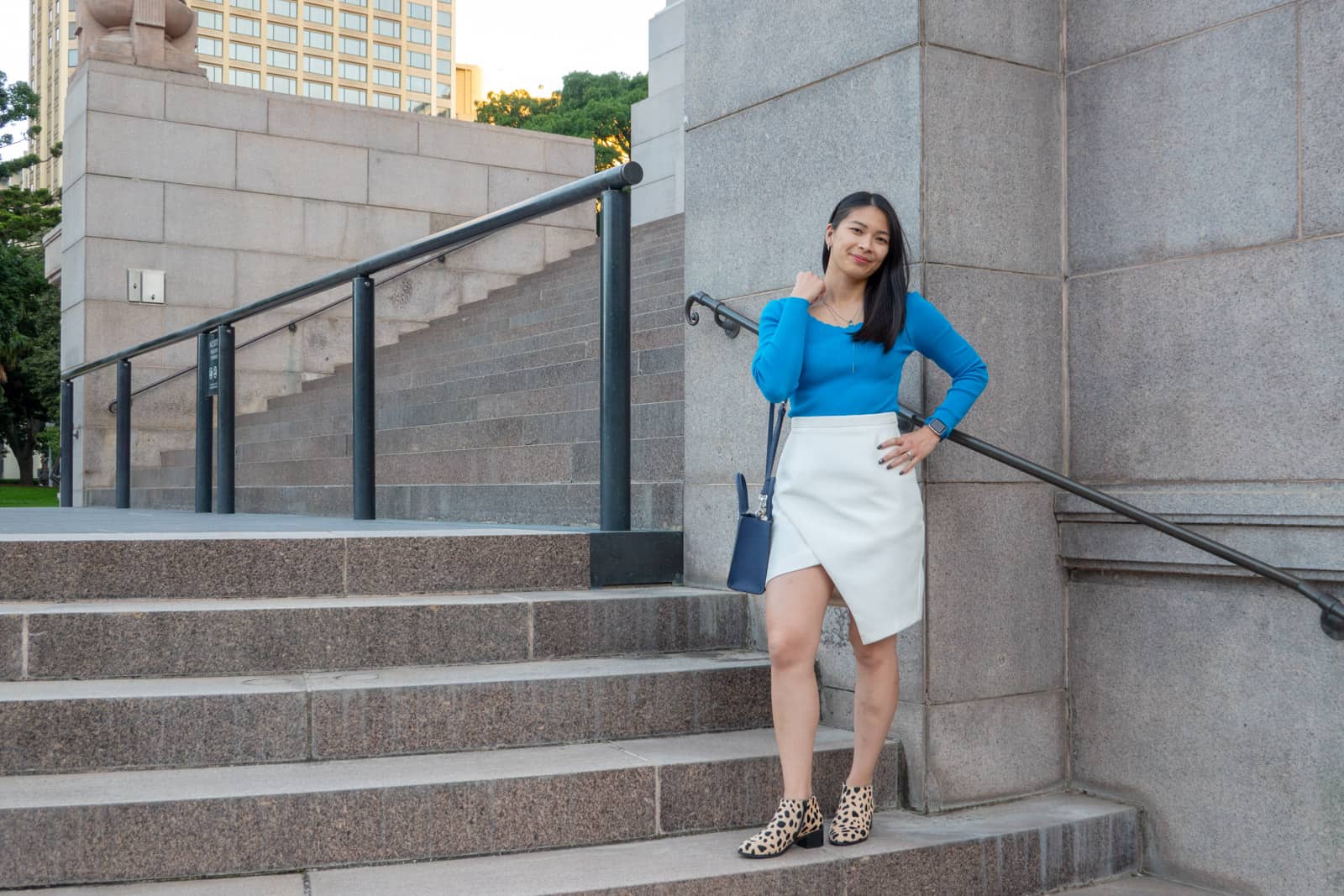 The same woman in other photos on this page, in the same outfit. She is standing on a flight of stone steps and has a hand on her hip.