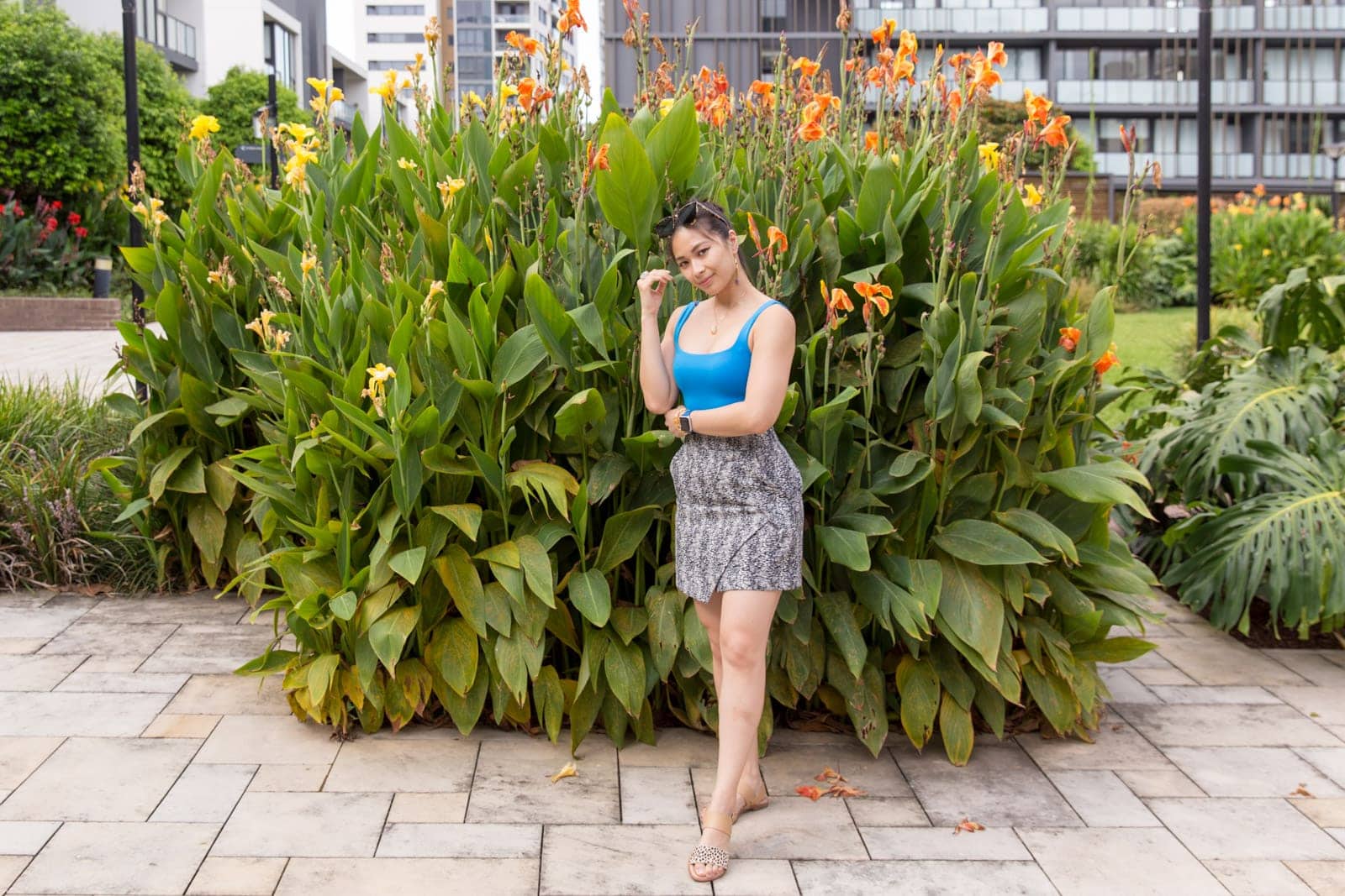 The same woman in other photos in this post, in the same outfit. She has a hand near her face, with that arm propped up by her other arm horizontally across her body