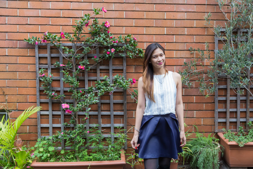 Standing against a brick wall with some florals