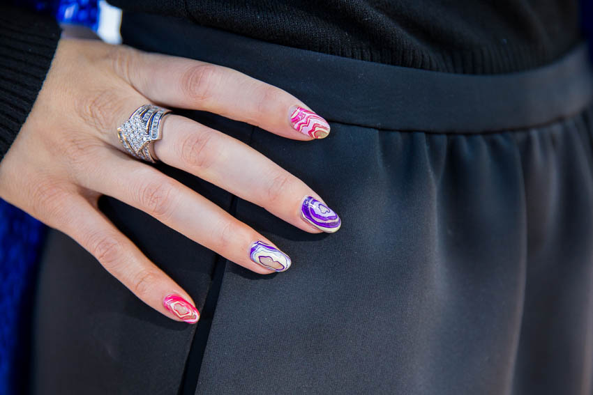 My right hand at my hip, showing a statement ring and geode-style nails