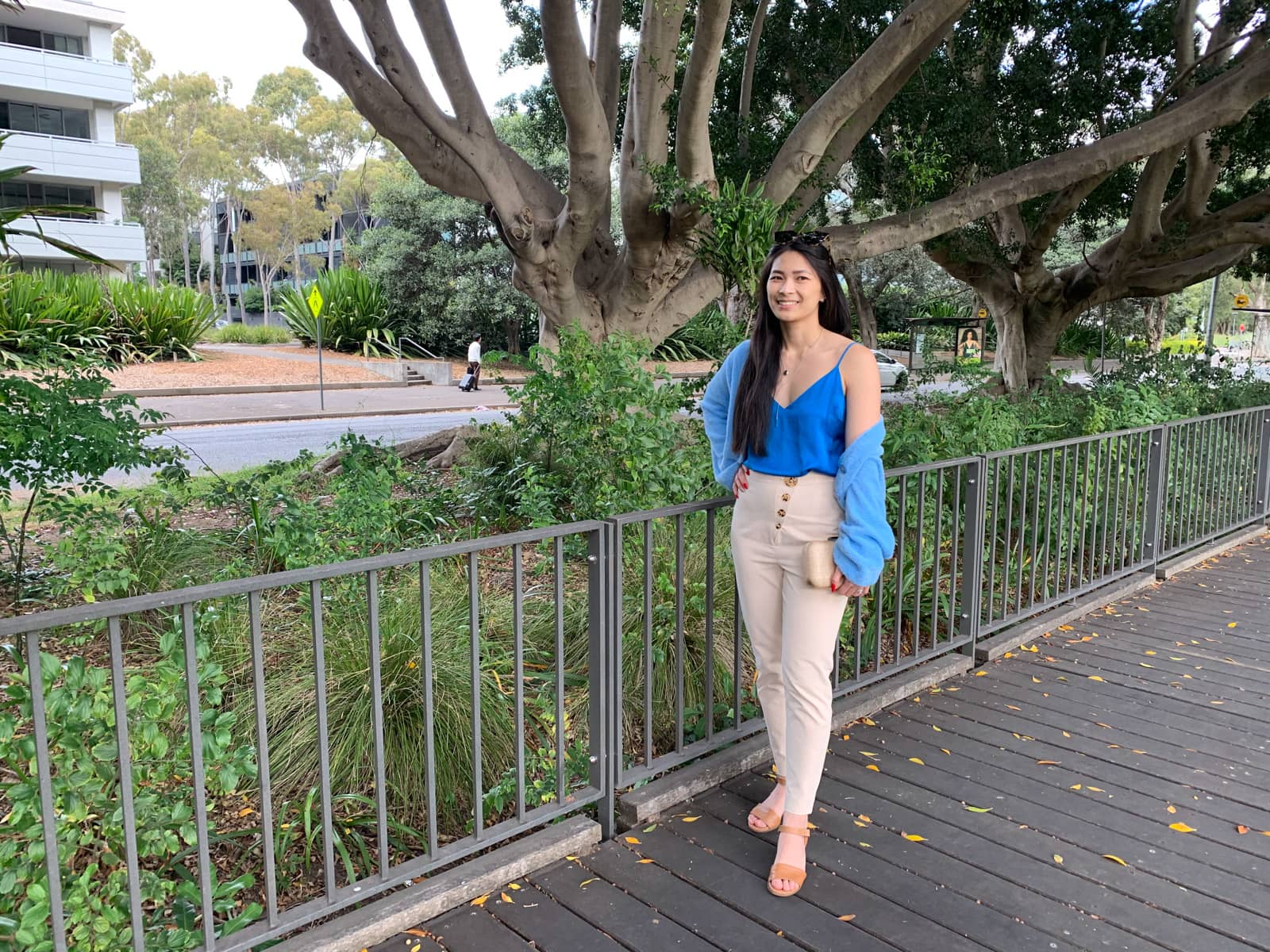 The same woman in the previous photos on this page, in the same outfit. She is standing on a wooden boardwalk and has a hand on her hip.