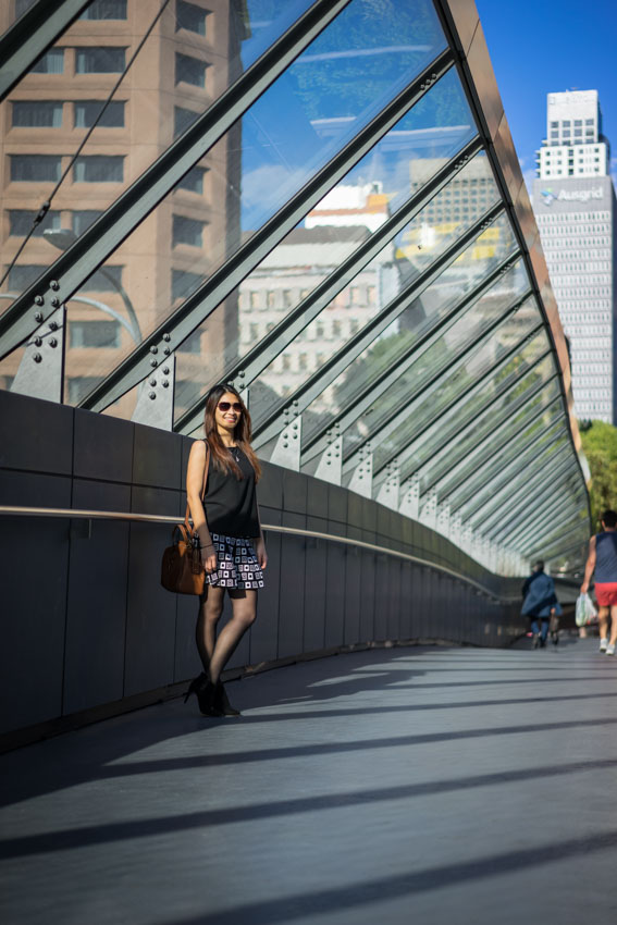 Me standing against the side of a footbridge with my bag on my shoulder