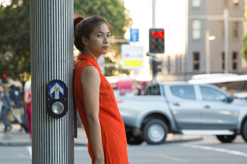 Me leaning against a pole with a pedestrian button with a car and traffic lights in the background