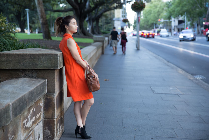 Me leaning on a short pillar on the edge of the park