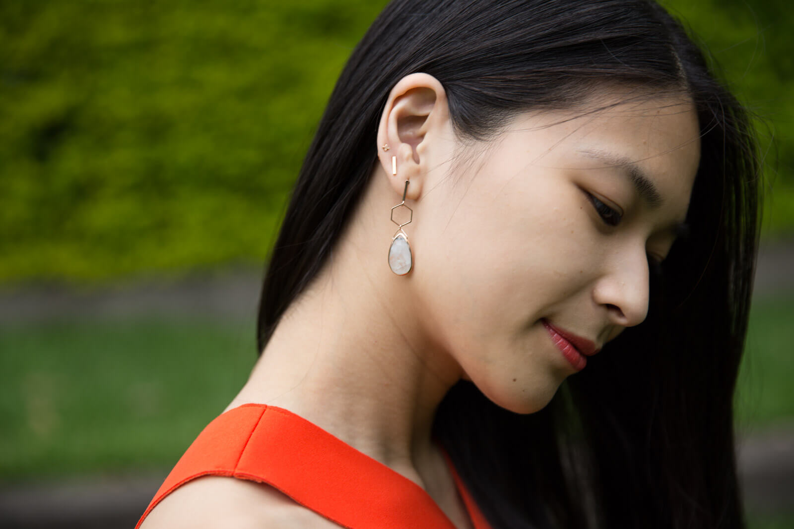 The same woman from other photos in this post, shown close up to show her rose gold earrings. The bottom-most earring has a moonstone drop